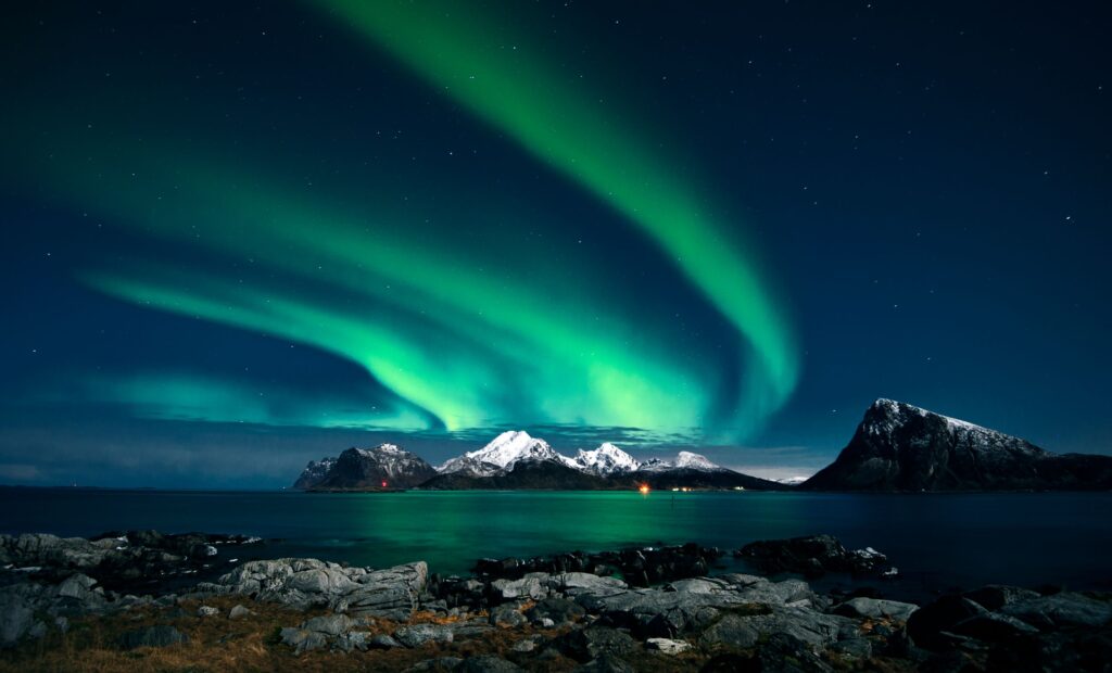 Northern lights over snow-covered mountains in Lofoten, Norway