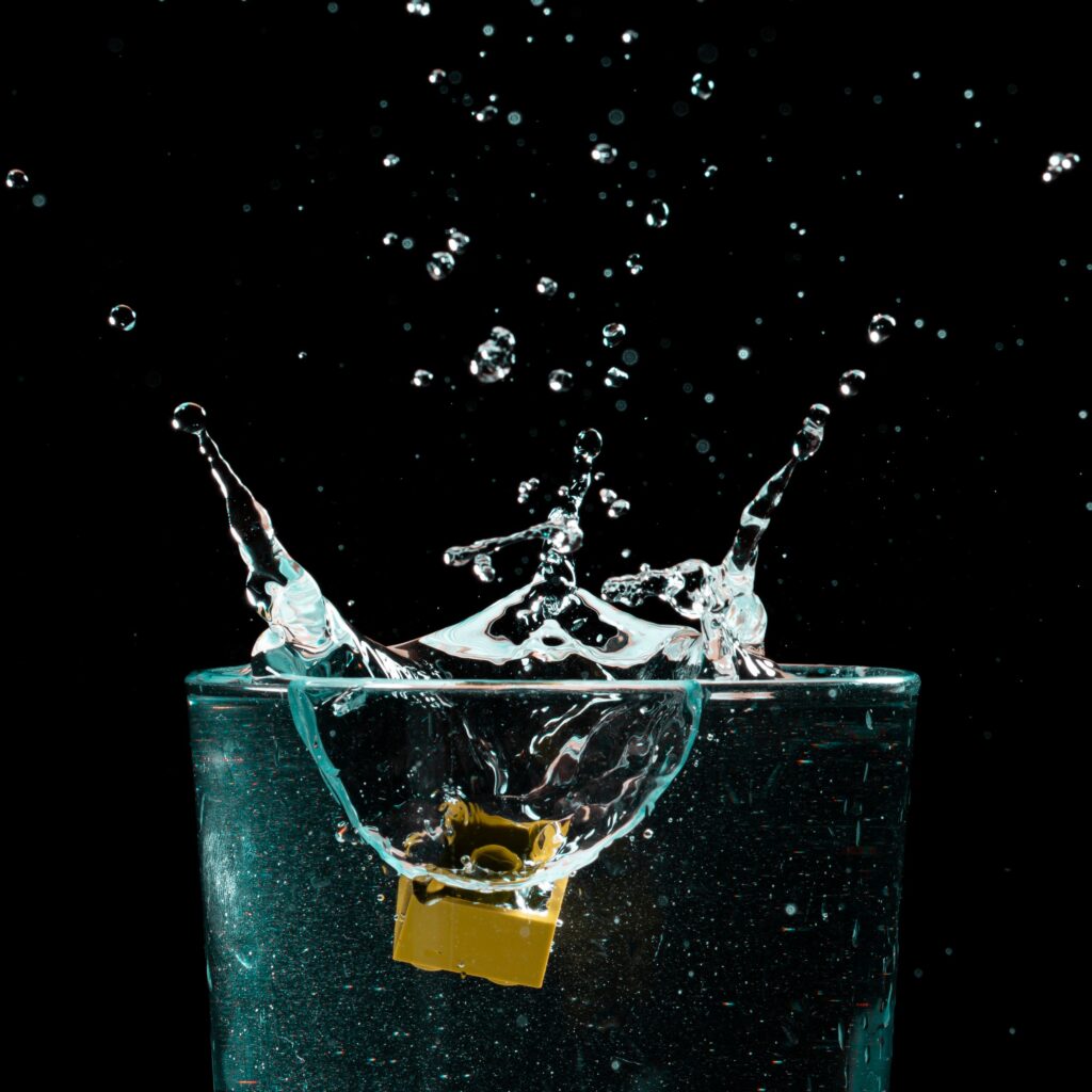 Water splashing inside a glass against a black background
